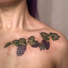 a woman's chest with grapes and leaves on it