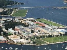 an aerial view of a large building in the middle of a body of water with sailboats floating around it