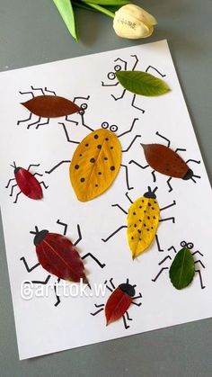 an art project with leaves and ladybugs on the paper, next to tulips