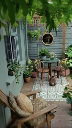 an outdoor patio with chairs, table and potted plants