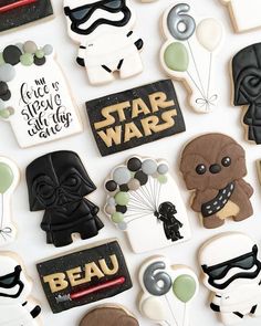 star wars decorated cookies are arranged on a white surface with black and gold lettering in the middle