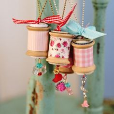 three spools of thread are hanging from the side of a green chair with bows on them