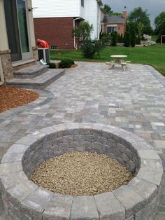 a fire pit in the middle of a brick patio