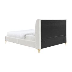 the bed frame is upholstered with black and white linens, while the headboard has gold legs