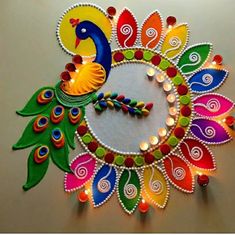 a colorful peacock made out of paper and lit candles