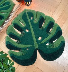 a large green rug on the floor next to a potted plant