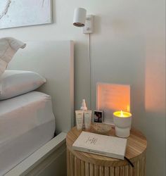 a table with a candle, soap and other items on it next to a bed