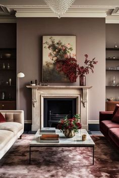 a living room filled with furniture and a fire place under a painting on the wall