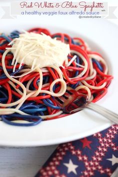 a white plate topped with pasta covered in red, white and blue noodles