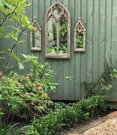 an outdoor area with plants and mirrors on the wall