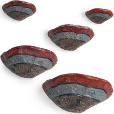 four pieces of red and grey pottery sitting next to each other