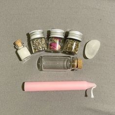 the contents of an assortment of beauty products on a gray surface with a pink toothbrush next to it