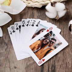 four playing cards with pictures of two women and one man on them next to cotton flowers