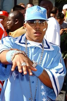 a man wearing sunglasses and a blue hat is standing in front of a group of people