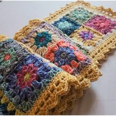 two crocheted squares are sitting on a table