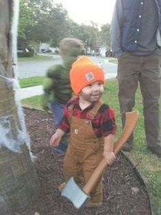 a little boy in an orange hat holding a shovel