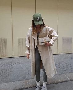 a woman in grey leggings and a trench coat