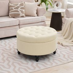 a living room with couches, chairs and a round ottoman on top of a rug