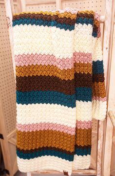 a crocheted blanket sitting on top of a chair