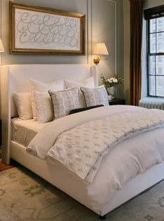 a bed with white sheets and pillows in a bedroom