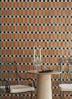 two chairs and a table with candles on it in front of a checkered wall