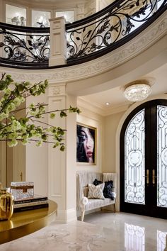 an elegant entryway with marble flooring and wrought iron railing