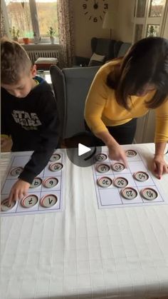 a woman and boy are playing with numbers on a table