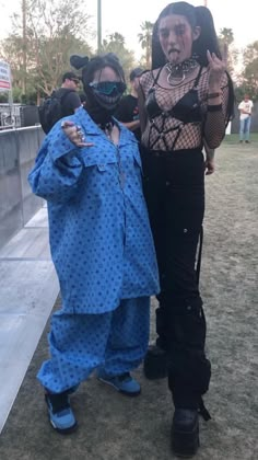 two women in blue outfits standing next to each other wearing black masks and face coverings