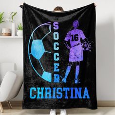 a woman holding up a black blanket with a soccer ball and the words soccce, cristina on it