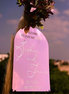 a welcome sign with flowers on it for someone to have their wedding written in white