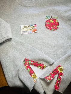 three pieces of clothing are sitting on a table with some stickers attached to them