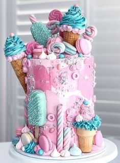 a pink and blue cake with ice cream cones on top