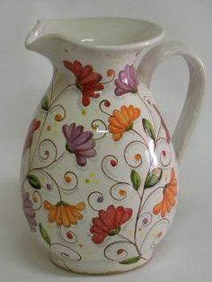 a white vase with colorful flowers painted on it