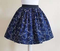 Constellations Skirt Gathered  full skirt made from a beautiful 100% cotton, Constelations fabric. Each skirt is made by gathering the fabric onto  a 2 inch black elastic waistband. The length measures from the top of the waistband and comes in three lengths, 19", 22" or 25". Please choose length from the drop down menu. The waist measurement can be seen in the measurement guide below. Please choose waist size from the drop down menu. The skirt is pictured with a petticoat to show its potential Space Skirt, Dinosaur Skirt, Dinosaur Fabric, Space Outfit, Space Gift, Star Blue, Gathered Skirt, Blue Skirt, Full Skirt