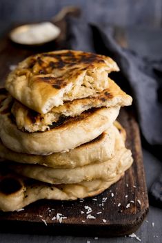 a stack of pancakes sitting on top of a wooden cutting board