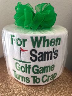 a golf themed toilet paper roll wrapped in green ribbon