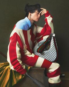 a painting of a woman in red and white striped sweater sitting on stairs with her hand on her head