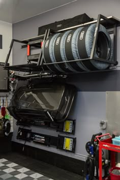 there is a car in the garage with many tires on it's shelfs