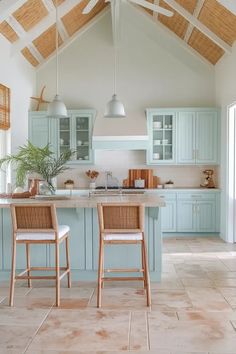 two chairs are in the middle of a kitchen with blue cabinets and white counter tops