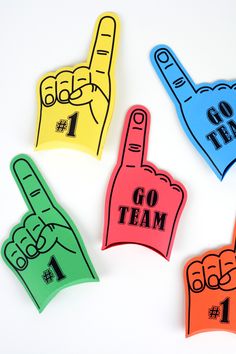 four different colored foam magnets with the words go team and one pointing finger up