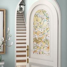 an open door leading to a hallway with flowers on the wall and stairs painted blue