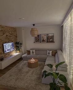 a living room filled with furniture and a flat screen tv mounted on the wall above it