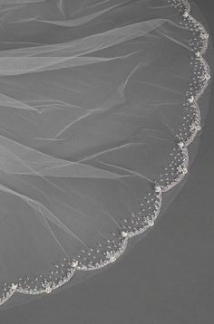 the bride's veil is adorned with pearls