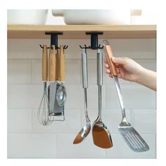 the kitchen utensils are hanging on the wall