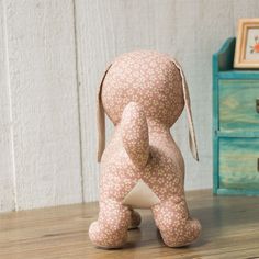 a small stuffed animal sitting on top of a wooden table next to a blue dresser