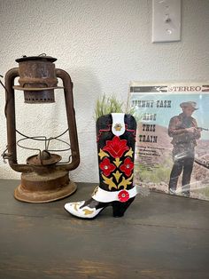 an old lamp, cowboy boots and magazine on a table