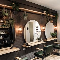 a hair salon with mirrors, chairs and plants on the wall in front of it