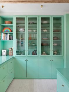 a kitchen with green cabinets and white floors