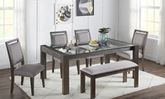 a glass dining table with four chairs and a bench in front of it on a rug