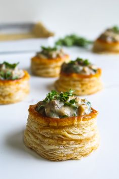 small pastries with various toppings on a white table top, ready to be eaten